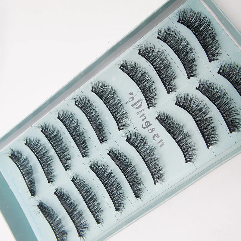 A tray of black mink false eyelashes displayed on a light blue background.
