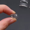 A hand holds a clear silicone ring size adjuster, showing the ring's inner diameter.