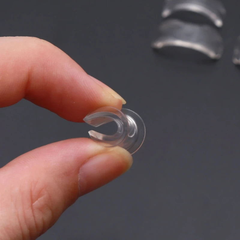 A hand holds a clear silicone ring size adjuster, showing the ring's inner diameter.