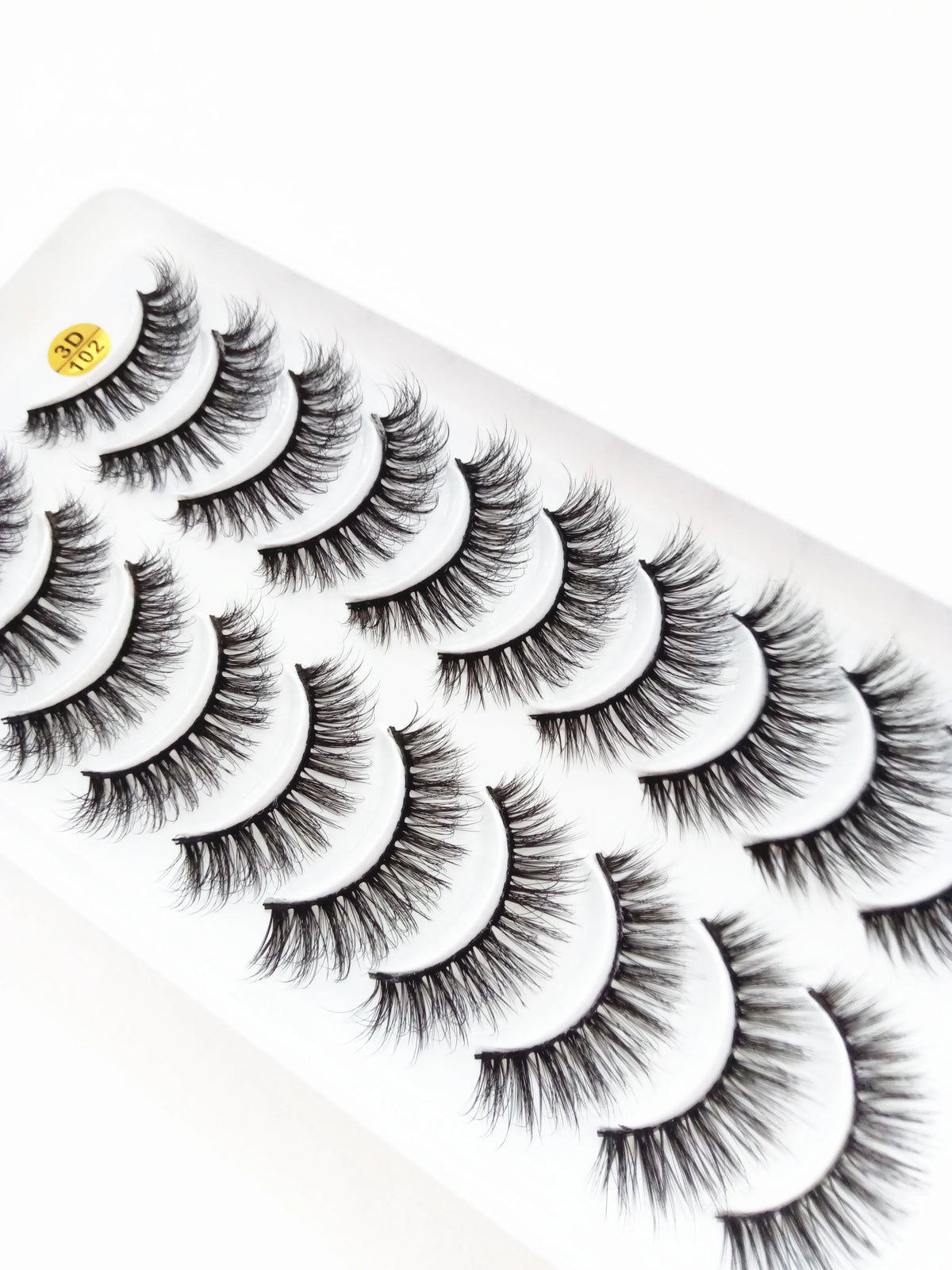 A strip of dramatic mink false eyelashes is shown, displaying various lash styles and lengths.