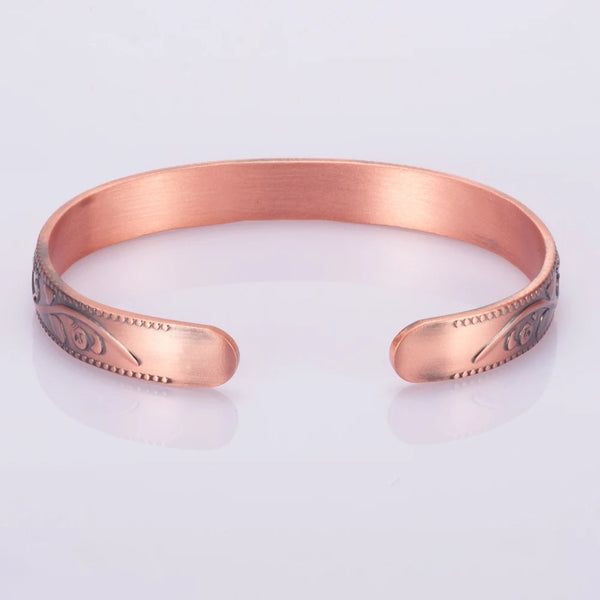A copper magnetic bangle bracelet featuring a plum flower design, shown against a white background.