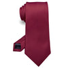 Cravate de soie jacquard marron, roulée et présentée sur fond blanc.
