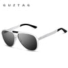 Silber-Aluminium-Sonnenbrille mit schwarzen Rahmen und dunklen Linsen vor weißem Hintergrund.