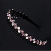 A close-up of a pink rhinestone anti-slip hairband featuring small clear and pink stones.