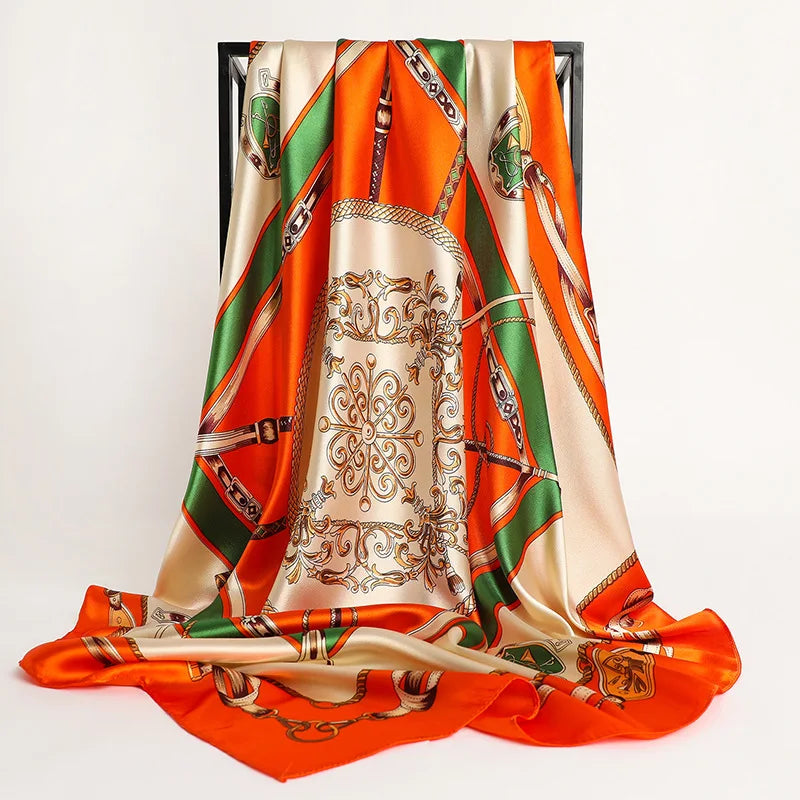 A luxurious satin silk scarf in orange and green tones draped vertically.