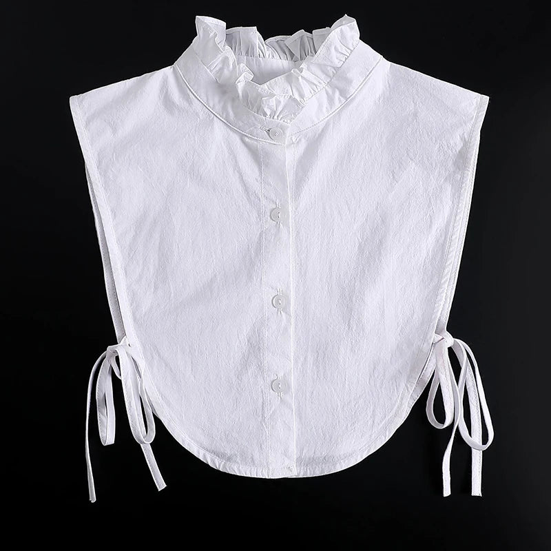White blouse with a ruffled false collar and tie strings at the sleeves