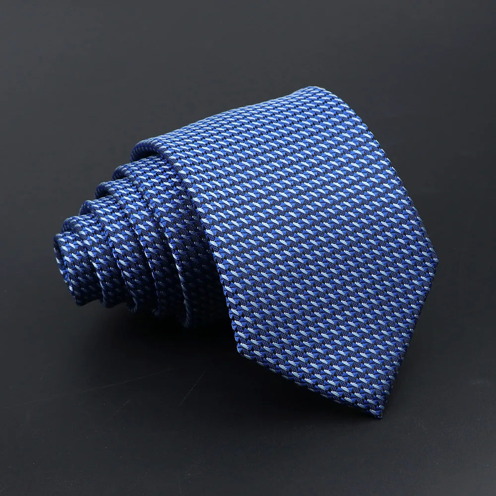 A dark blue woven necktie with a subtle plaid pattern, folded and displayed against a black background.