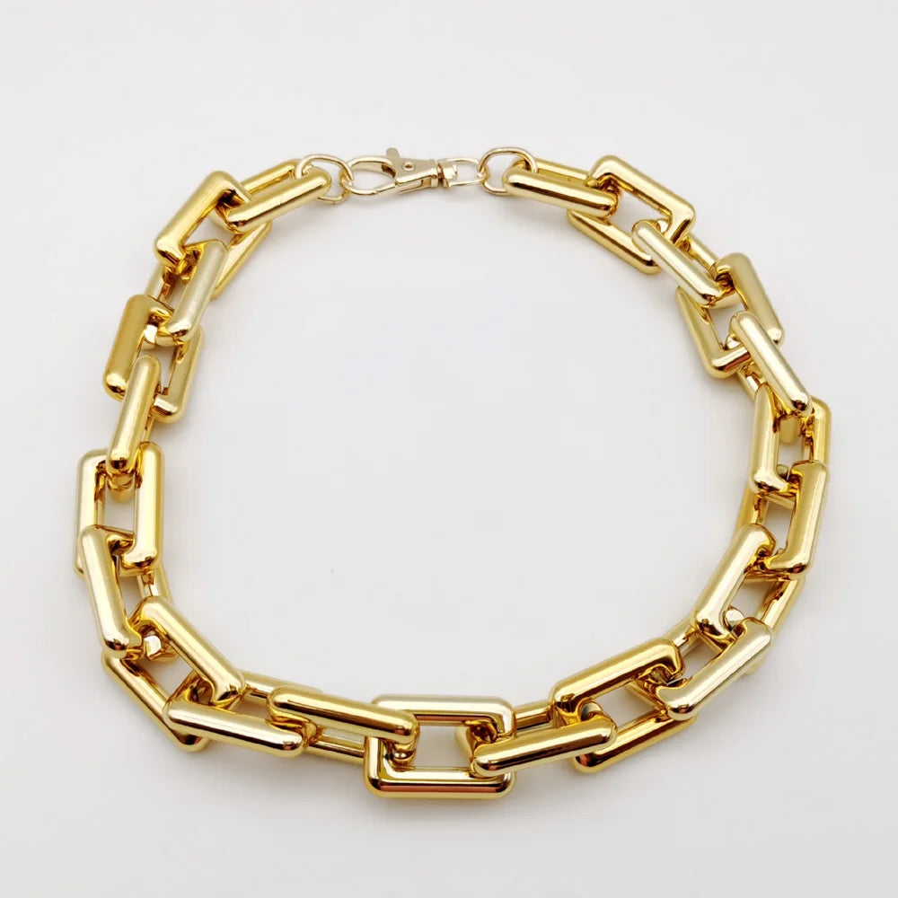 A gold-colored boho punk twisted link chain necklace laid flat against a white background.