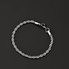 A silver stainless steel twisted rope chain bracelet laid flat on a dark background.
