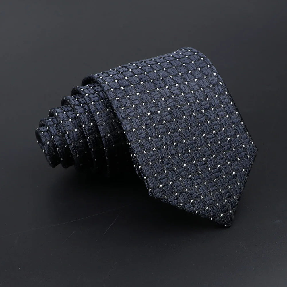 A dark navy blue classic men's tie featuring a subtle plaid dot pattern, rolled and displayed on a dark background.