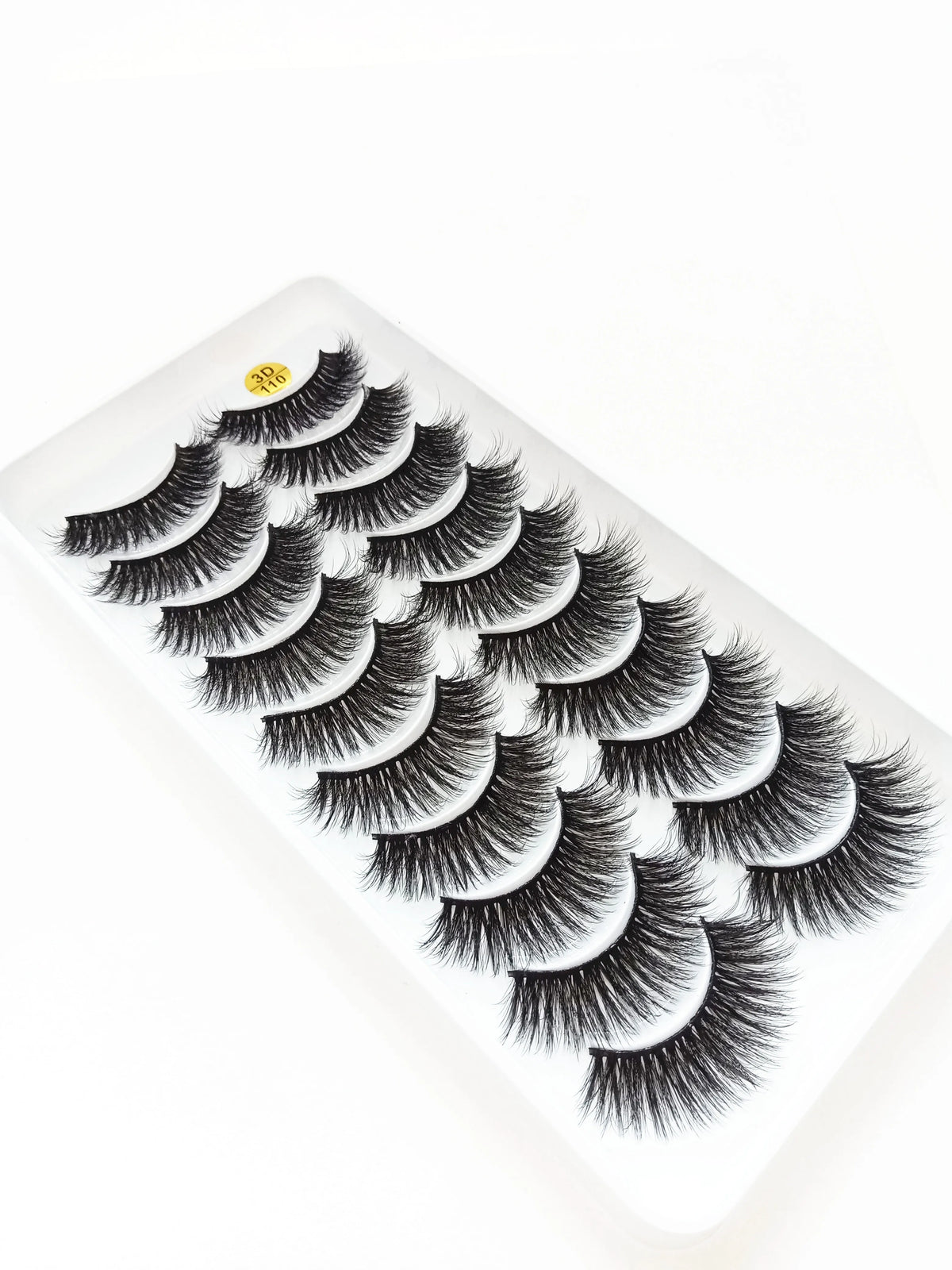 A close-up of dramatic mink false eyelashes displayed on a white surface.