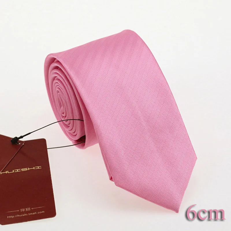 Pink gestreifte Krawatte, gerollt und neben einem braunen Etikett ausgestellt.