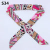 A patterned silk headband scarf featuring multi-color geometric and leopard print designs.