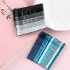 A set of 24 glitter wavy hair clips and bobby pins in various shades of black, gray, and blue are displayed on a pink surface