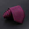 A dark magenta plaid tie is rolled and displayed against a black background.
