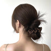 A dark brown hair styled in a messy bun with wispy tendrils, showcasing luxury pure silk hair scrunchies.