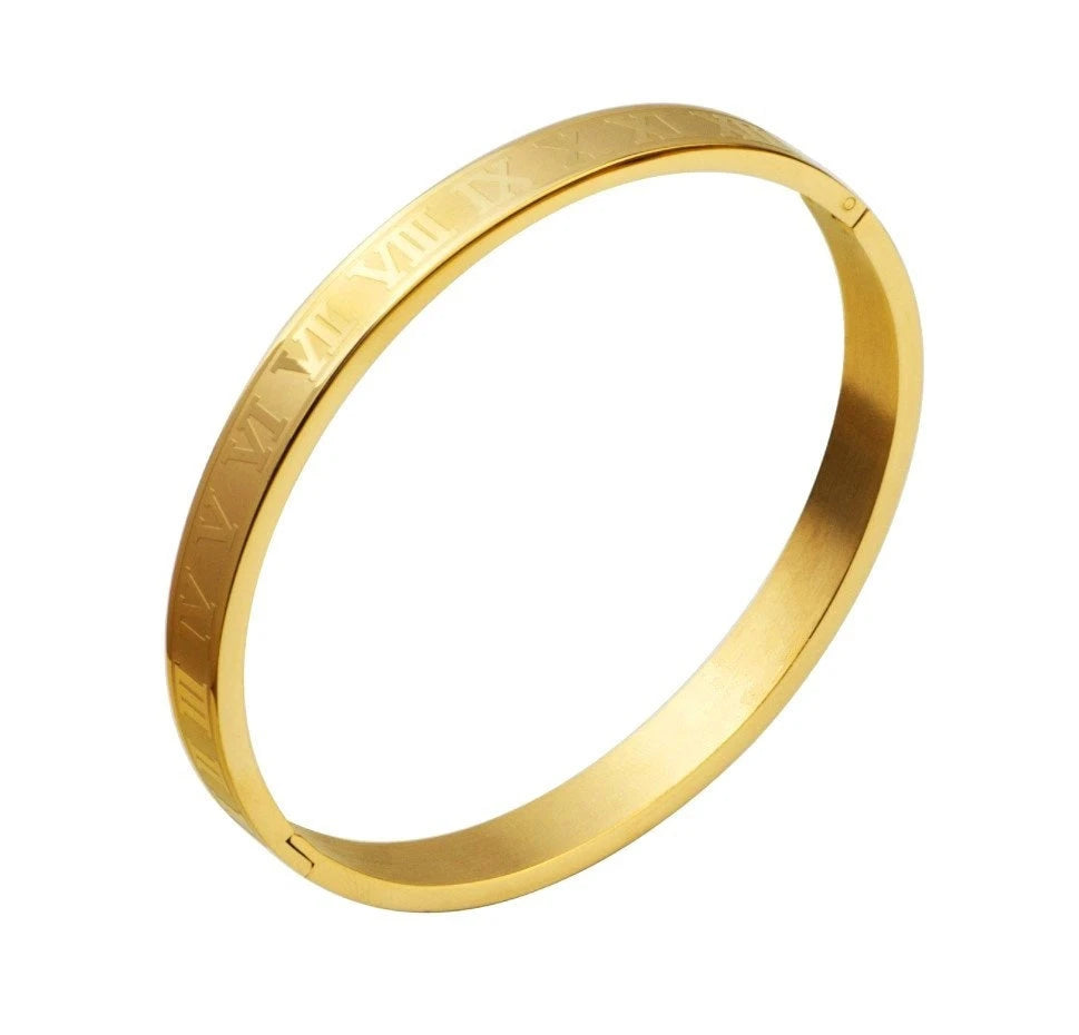A gold-toned stainless steel ring engraved with Roman numerals on its surface.