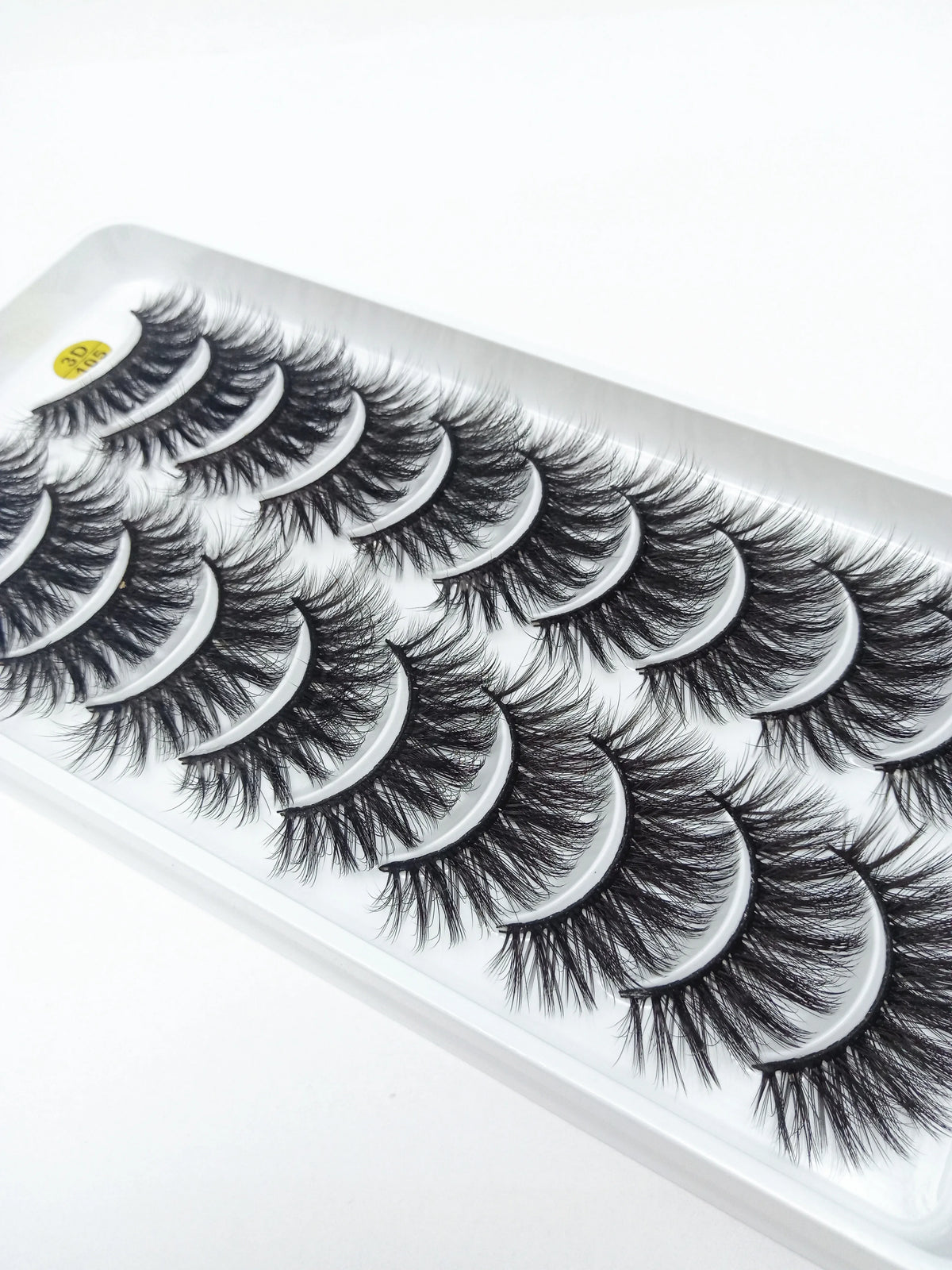 A tray of dramatic mink false eyelashes displayed on a white background.