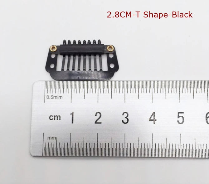 Une pince pour extensions de cheveux noire avec dix dents, à côté d'une règle pour l'échelle.