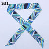 A multi-color leopard print silk headband scarf tied in an 'X' shape.