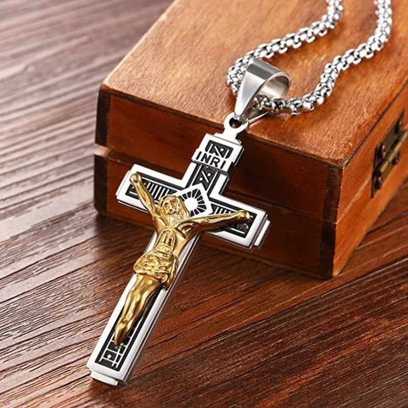 A gold-colored retro Christian cross amulet necklace displayed on a wooden box.