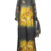 A long, flowing kaftan dress featuring a dark background with vibrant yellow and green floral patterns.