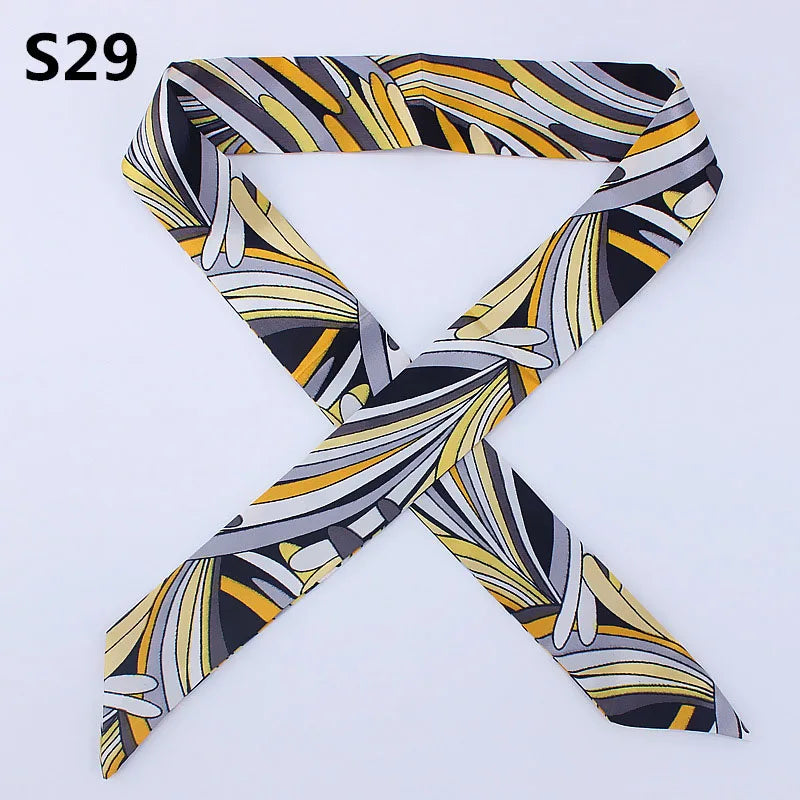 A black and white patterned silk headband scarf tied in an 'X' shape.