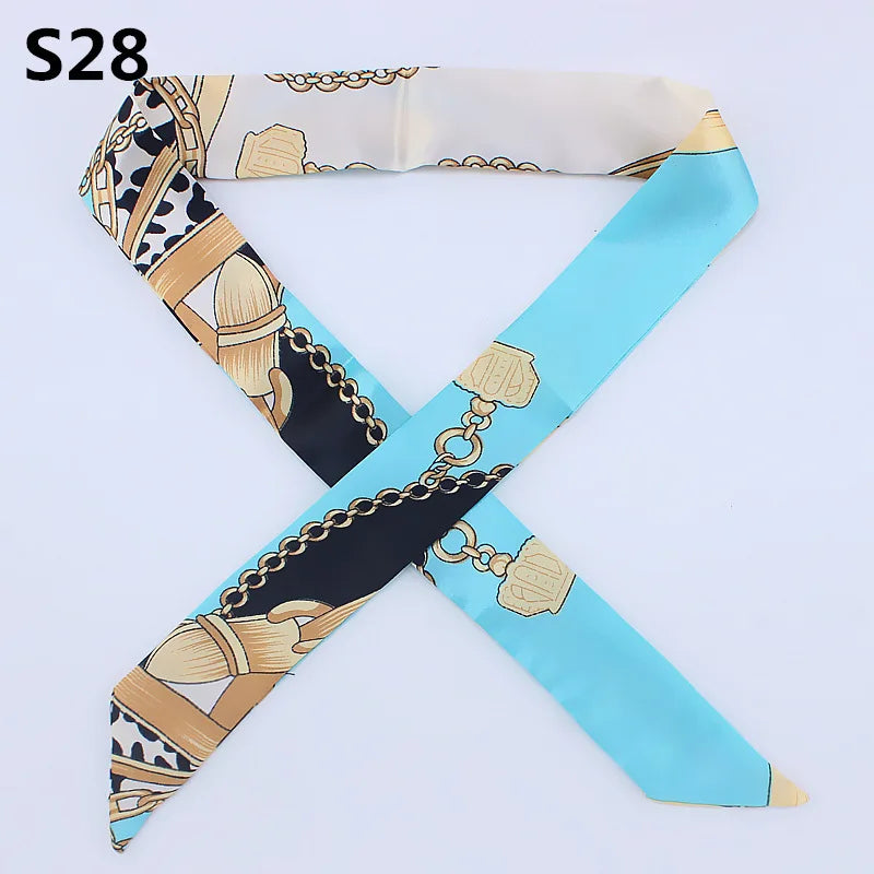 A silk headband scarf featuring a multi-color leopard print design with gold chain accents.