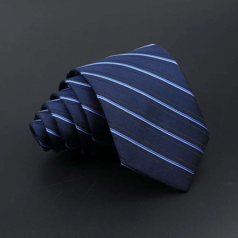 A dark blue striped necktie folded into a fan shape on a dark background.