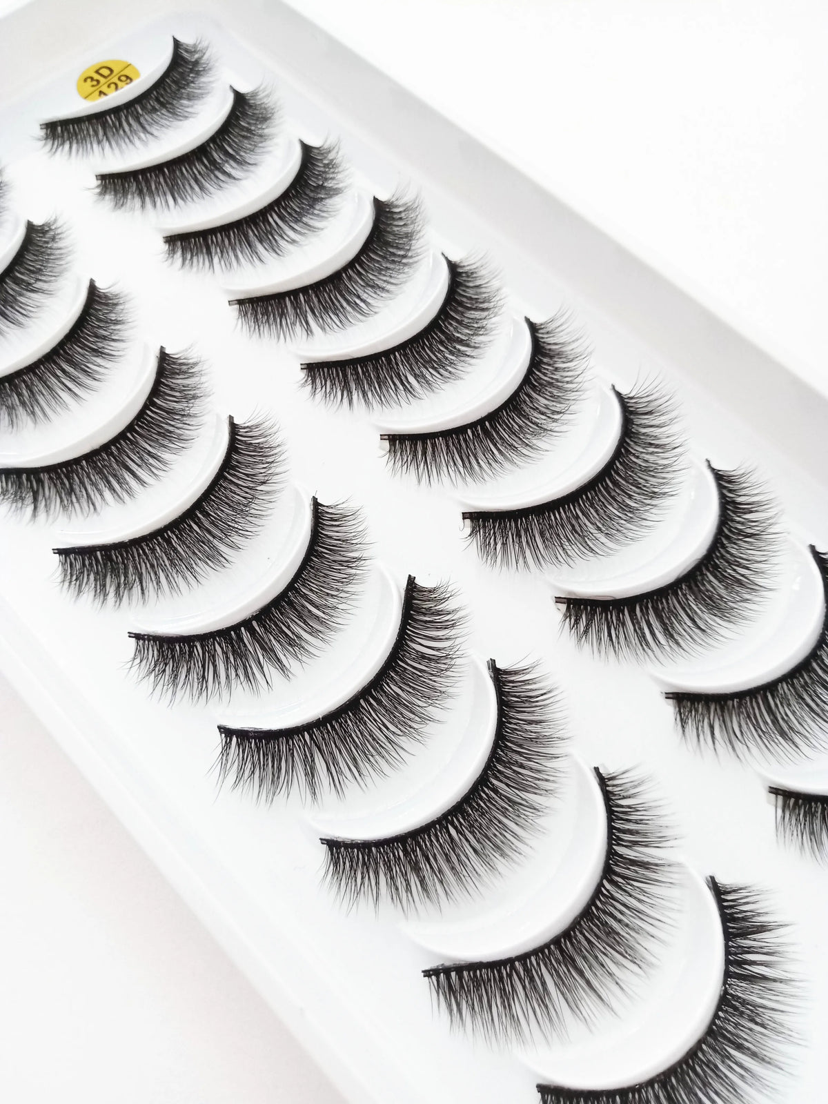 A display of dramatic mink false eyelashes in various styles on a white plastic tray.