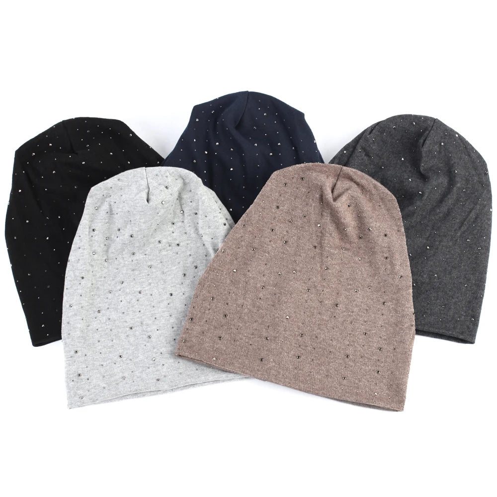 A collection of four gray and black rhinestone beanie hats displayed on a white background.