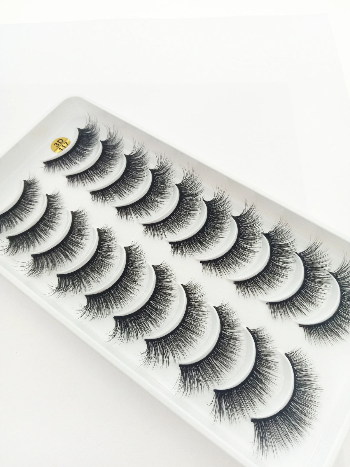A display of dramatic mink false eyelashes on a white tray.