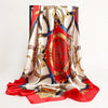 A luxurious satin silk scarf featuring intricate gold and blue patterns on a red background.