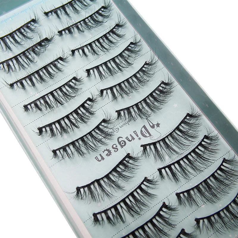 Close-up display of various styles of black mink false eyelashes on a clear background.