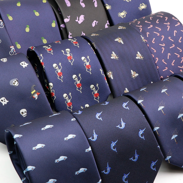 A close-up of a dark blue silk jacquard men's neck tie featuring a repeating pattern of skulls and bats.