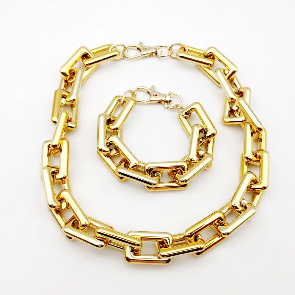A gold-colored boho punk twisted link necklace laid out on a white background.