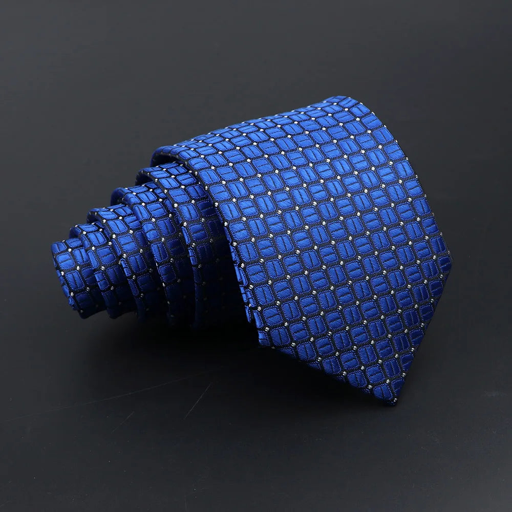 A dark blue classic men's tie featuring a repeating plaid dot pattern, shown in a coiled form.