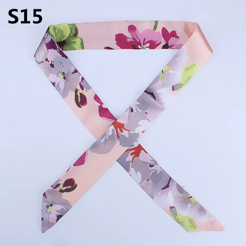 Pink silk headband scarf with multi-color floral print in shades of purple, green, and mauve.