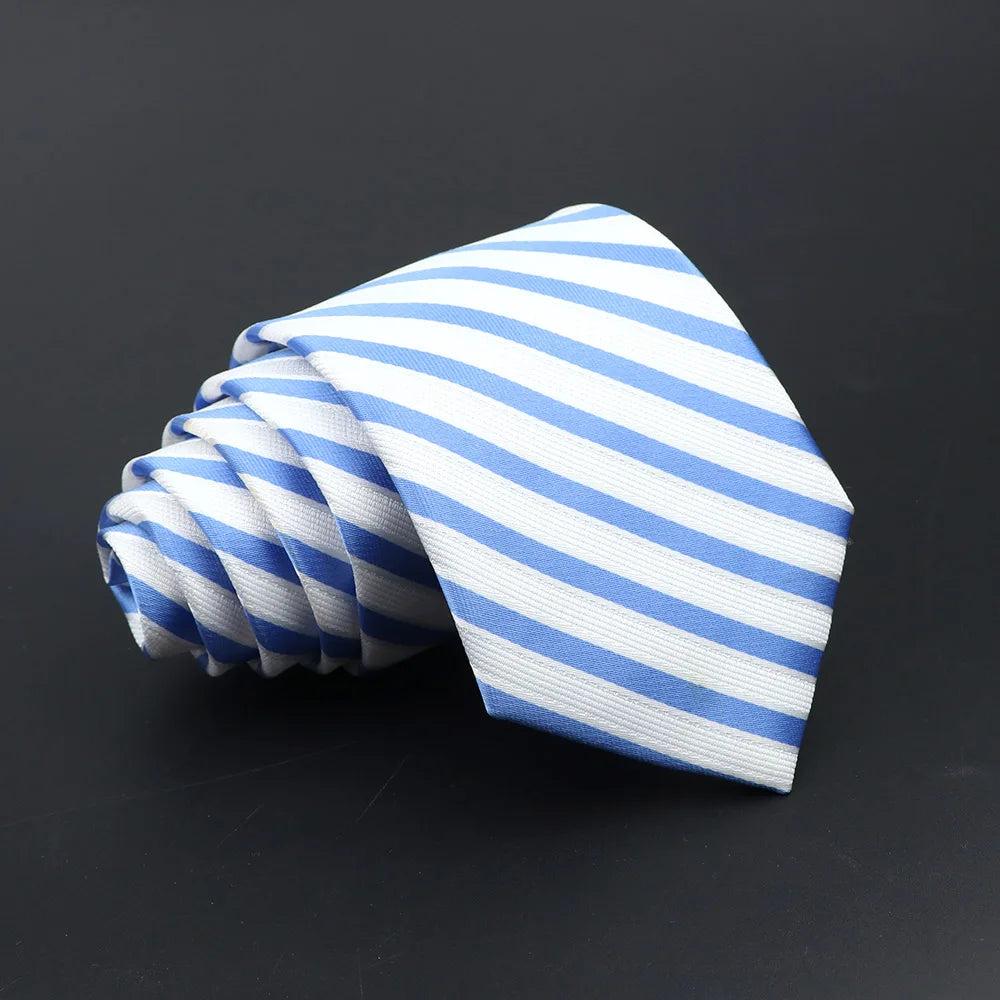 A folded blue and white striped men's tie lying on a dark surface.