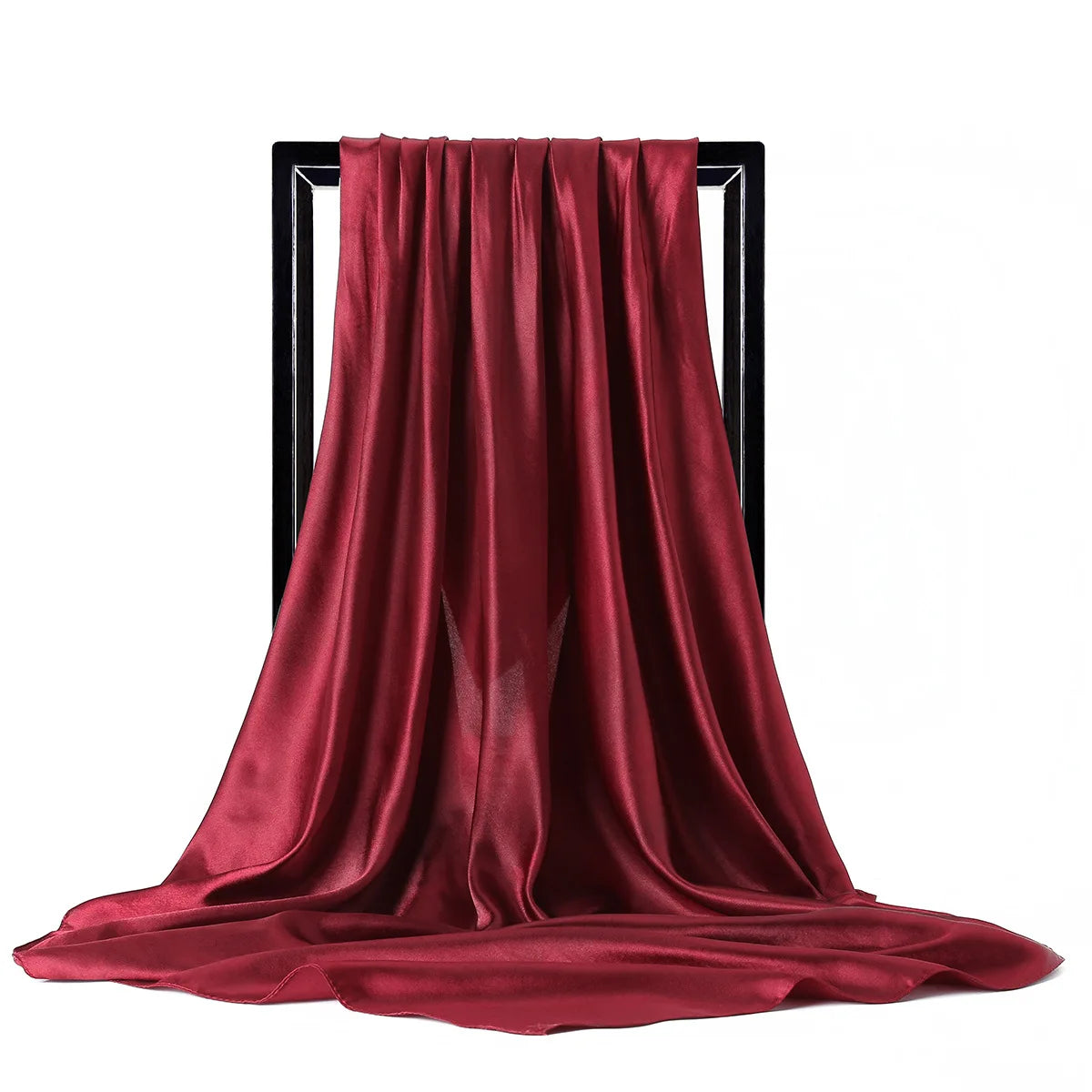 Una bufanda de seda satinada de color rojo intenso drapeada sobre un soporte negro.