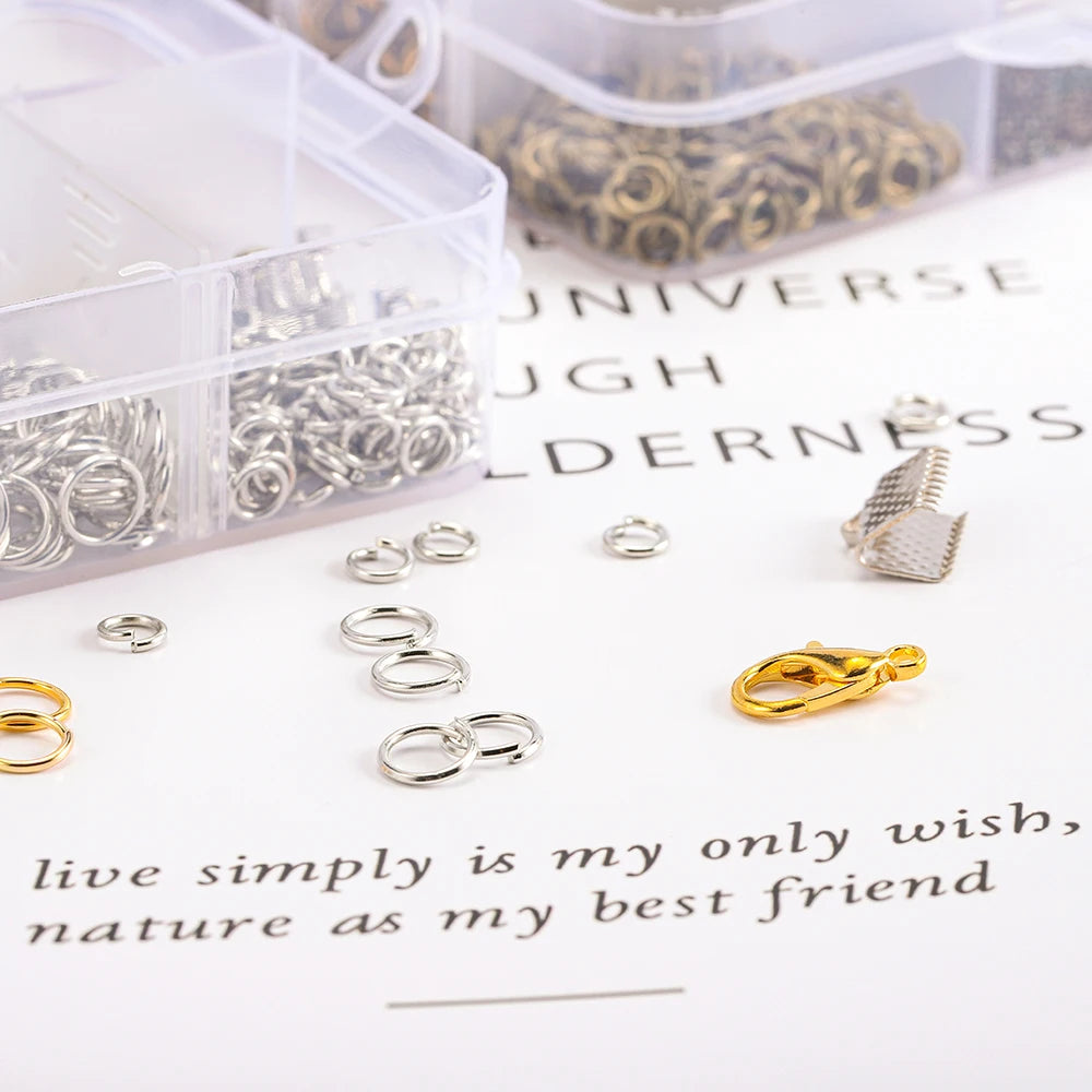A collection of silver jewelry findings including clasps, hooks, and jump rings displayed on a white surface.
