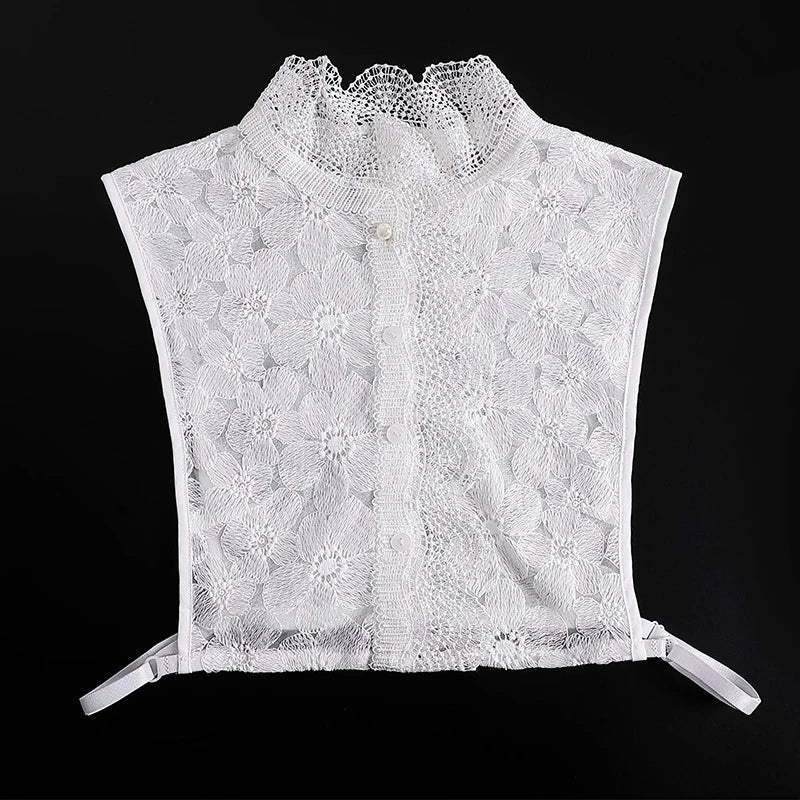 White lace blouse with a ruffled false collar and a button closure.
