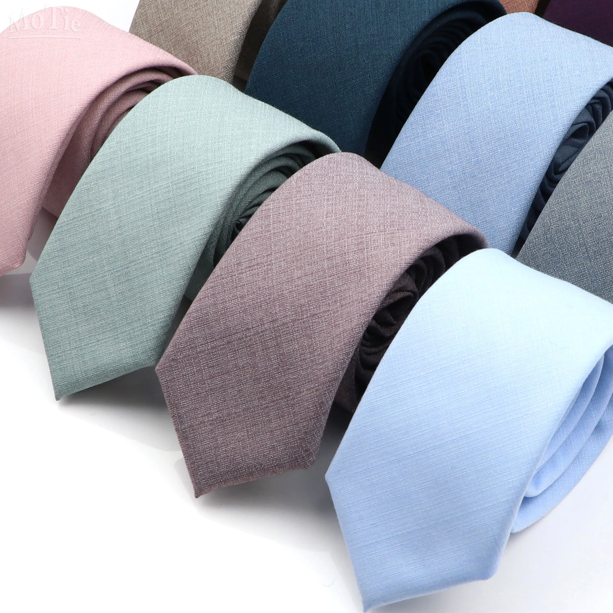 A collection of men's solid color anti-wrinkle bamboo fiber ties in various shades of pink, blue, and gray.
