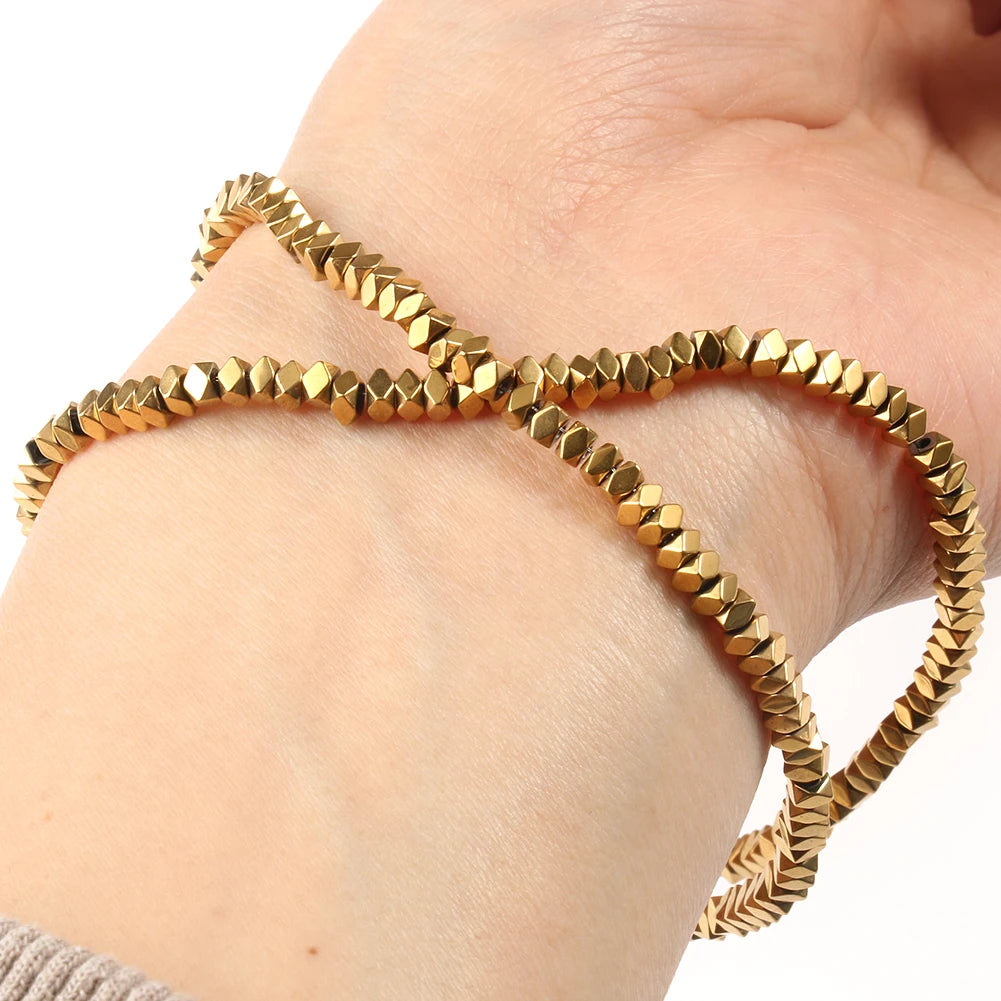 Gold-plated hematite round cube beads strung together on a wrist.