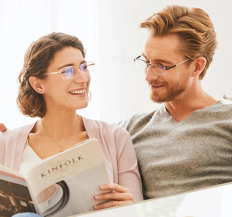 A woman smiling while reading a book, next to a man wearing progressive multifocus reading glasses.