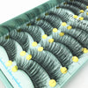 A tray of black mink false eyelashes is displayed on a light green surface.