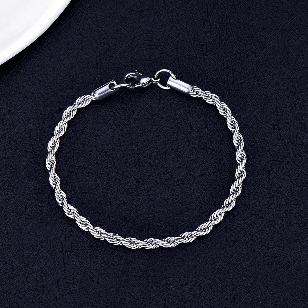 A silver stainless steel twisted rope chain bracelet laid on a dark surface.