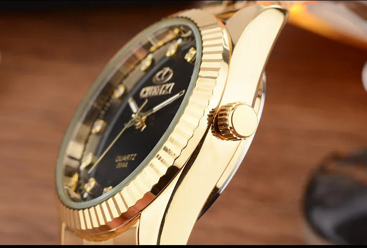 A close-up shot of a luxury golden quartz wristwatch with a gold bezel and dark dial on a wooden surface.