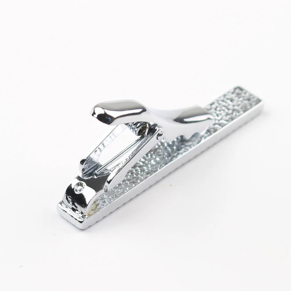 Clip de corbata de acero inoxidable plateado con textura y cierre decorativo.
