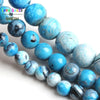 A strand of natural sky blue fire agate spacer beads for DIY jewelry, showing various shades and textures.